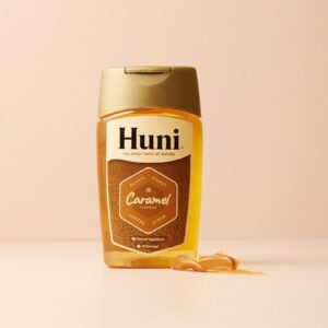 A bottle of huni caramel syrup with syrup spilled out